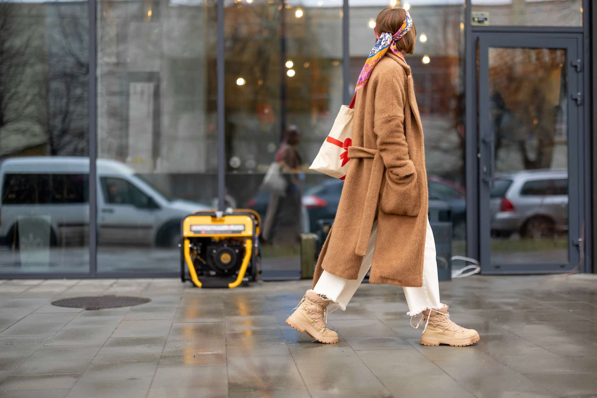 Woman walks on a street with gasoline generator