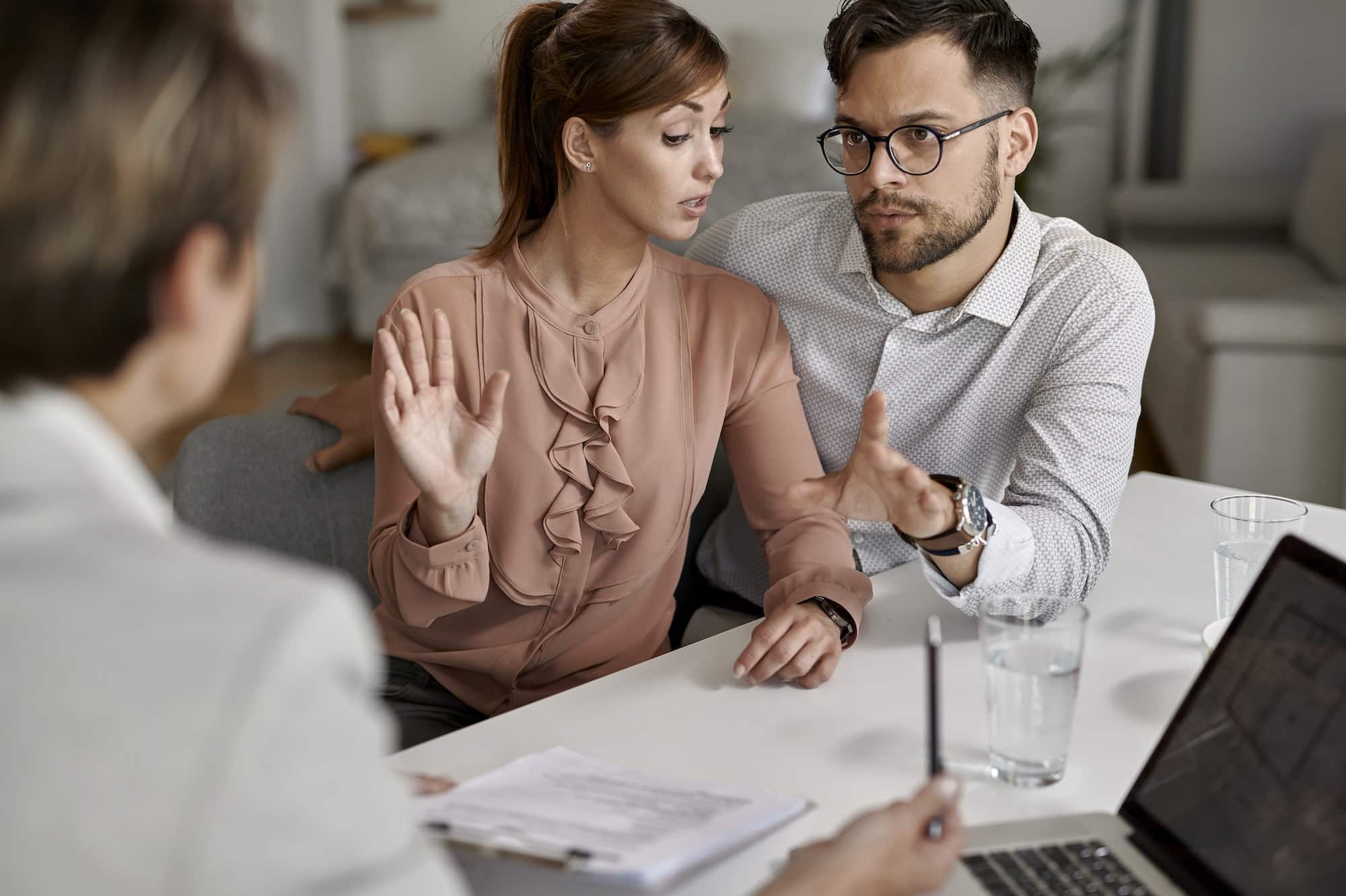 Young couple communicating with insurance agent during a meeting.