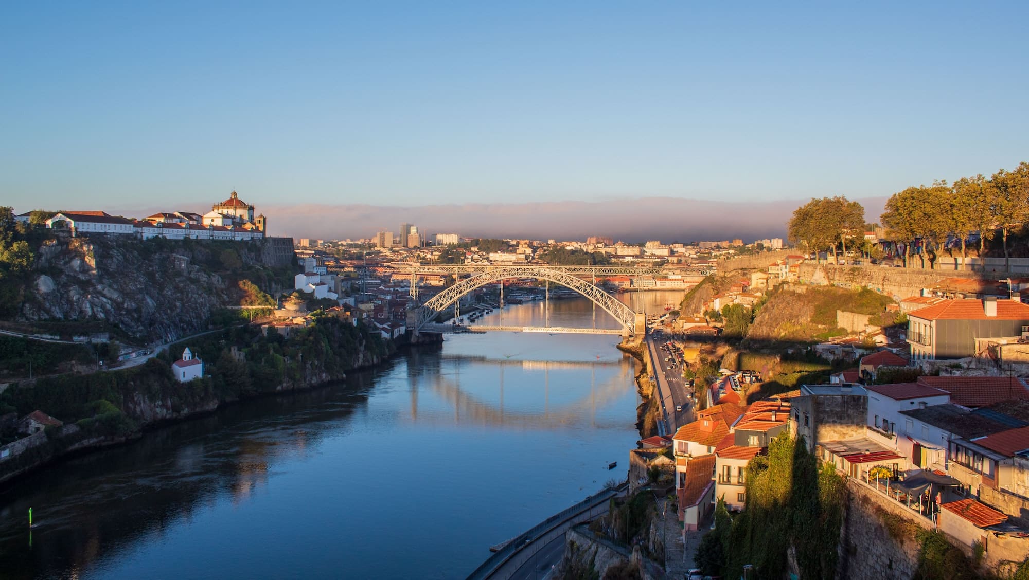 Aerial view of the Ponte Dona Maria Pia bridge crossing over the river under the blue sky