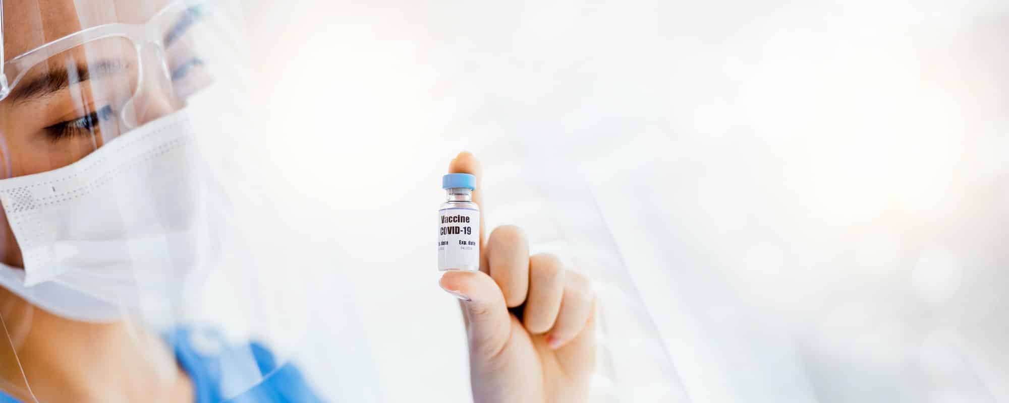 Close up woman doctor holding bottle of vaccine ready for injection