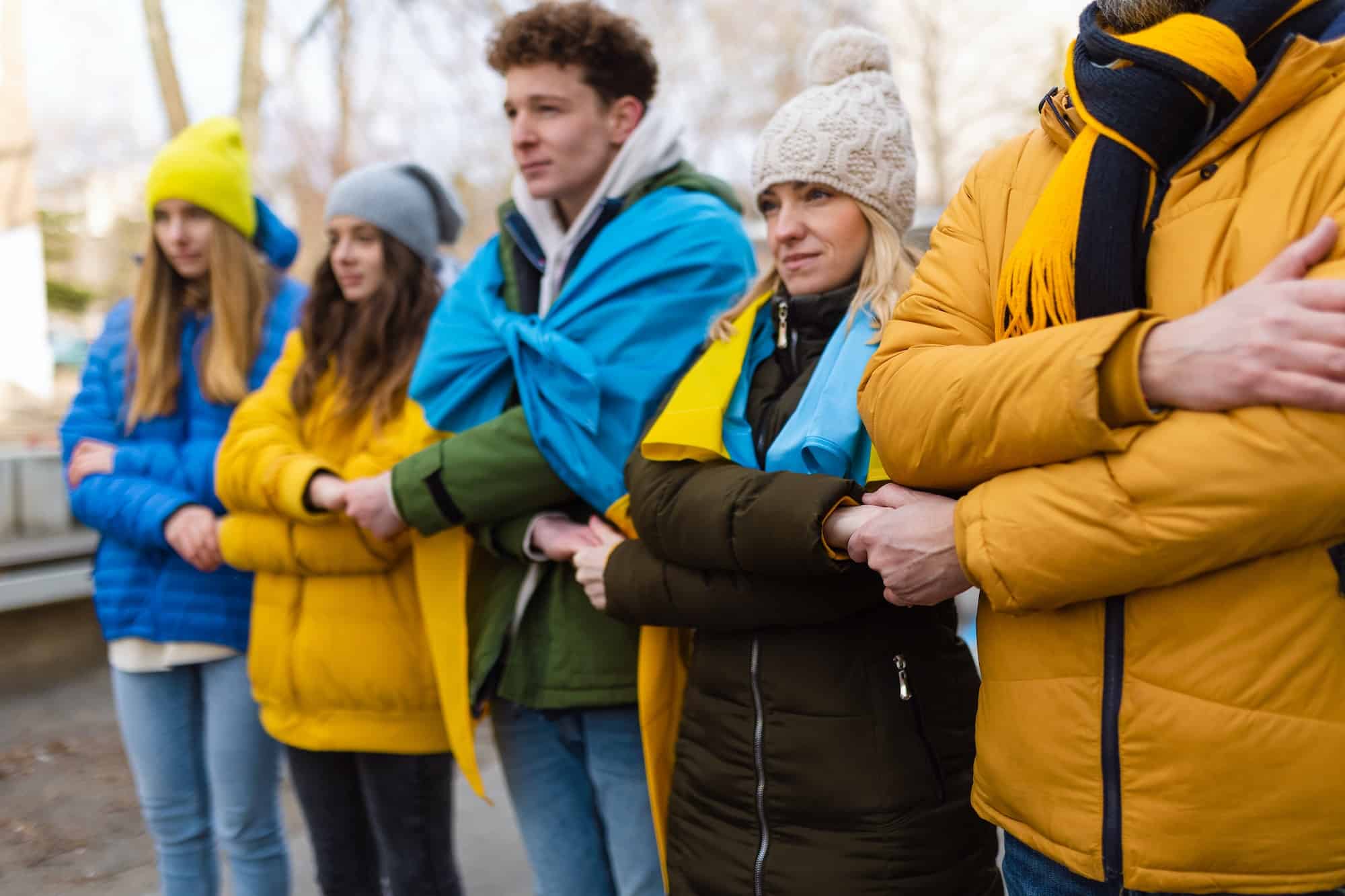 Protestors with Ukrainian blue and yellow flags protesting against war in Ukraine in street