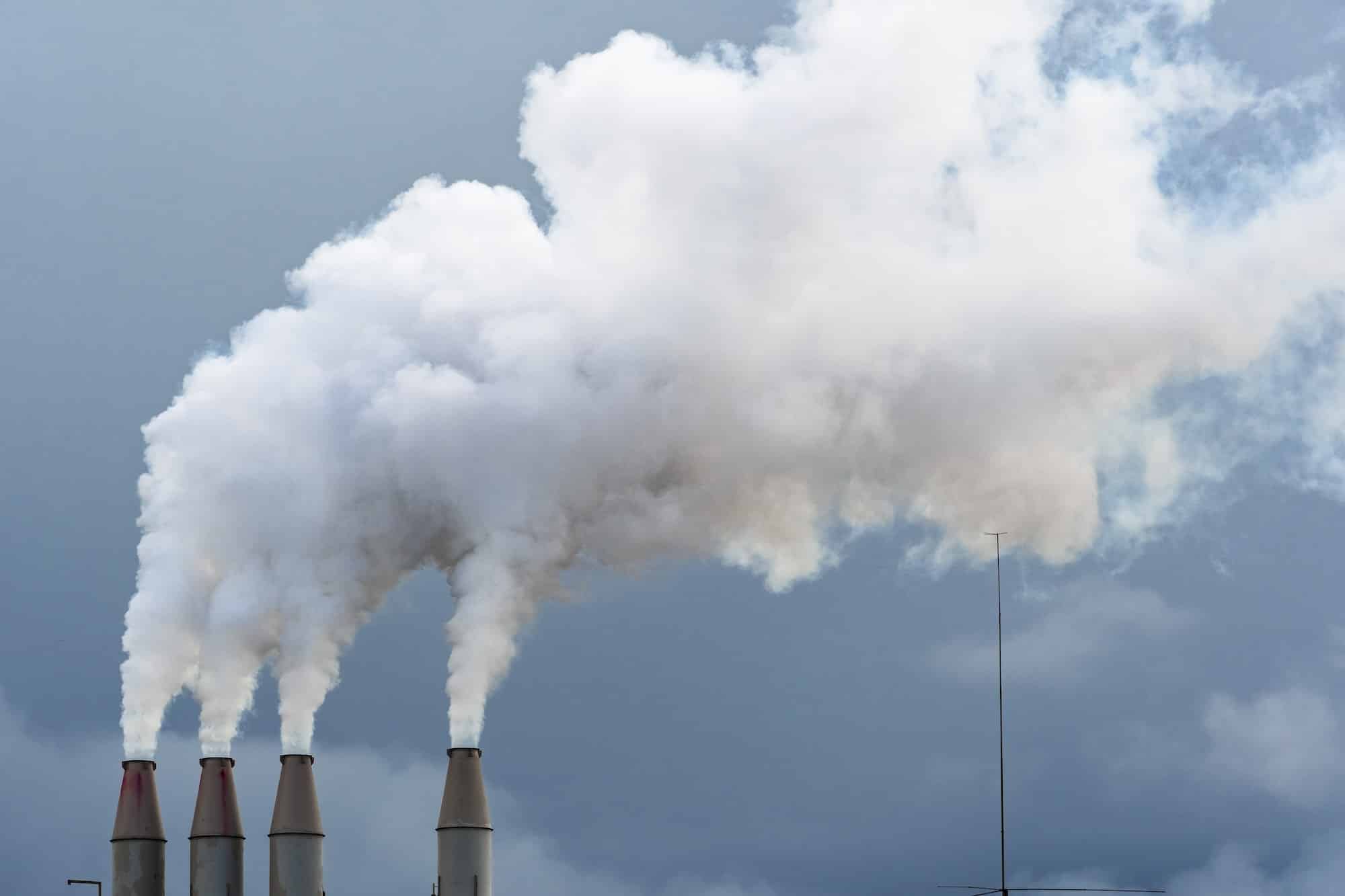 Smoke and steam rising into the air from power plant stacks