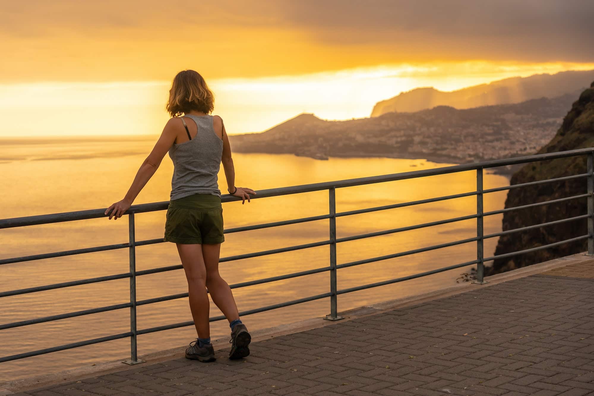 Young woman tourist at Mirador de Cristo Rei at sunset in Funchal in summer, Madeira