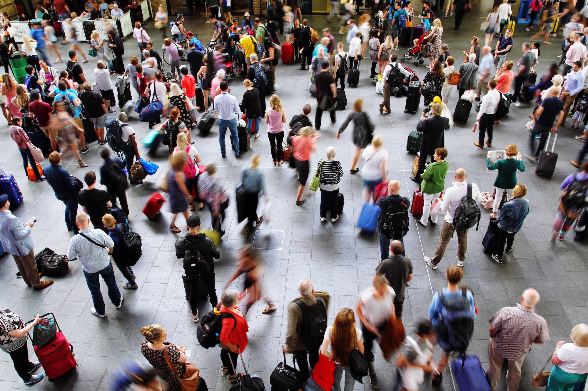 A crowded train station or airport with passengers, commuters and people waiting city transportation