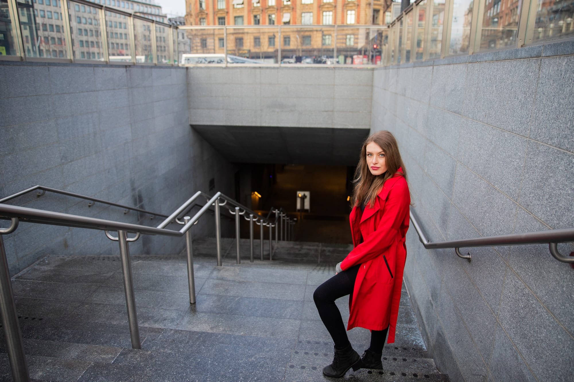 An attractive girl is walking down the stairs and going to take the metro