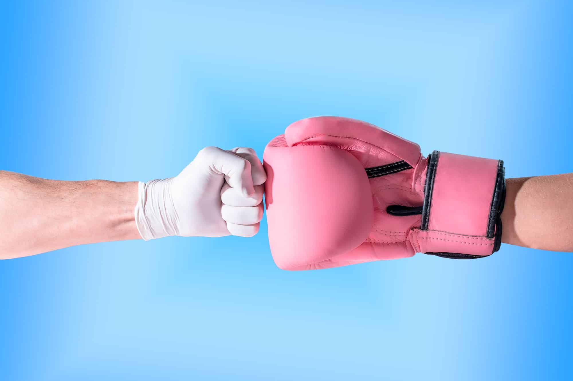 Fist of a nurse/doctor against a boxing glove