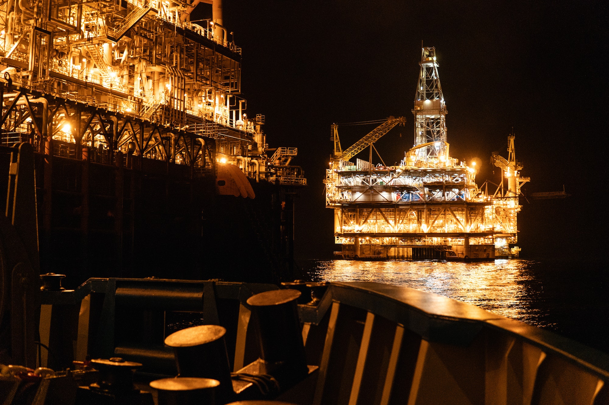 FPSO tanker vessel near Oil platform Rig at night. Offshore oil and gas industry