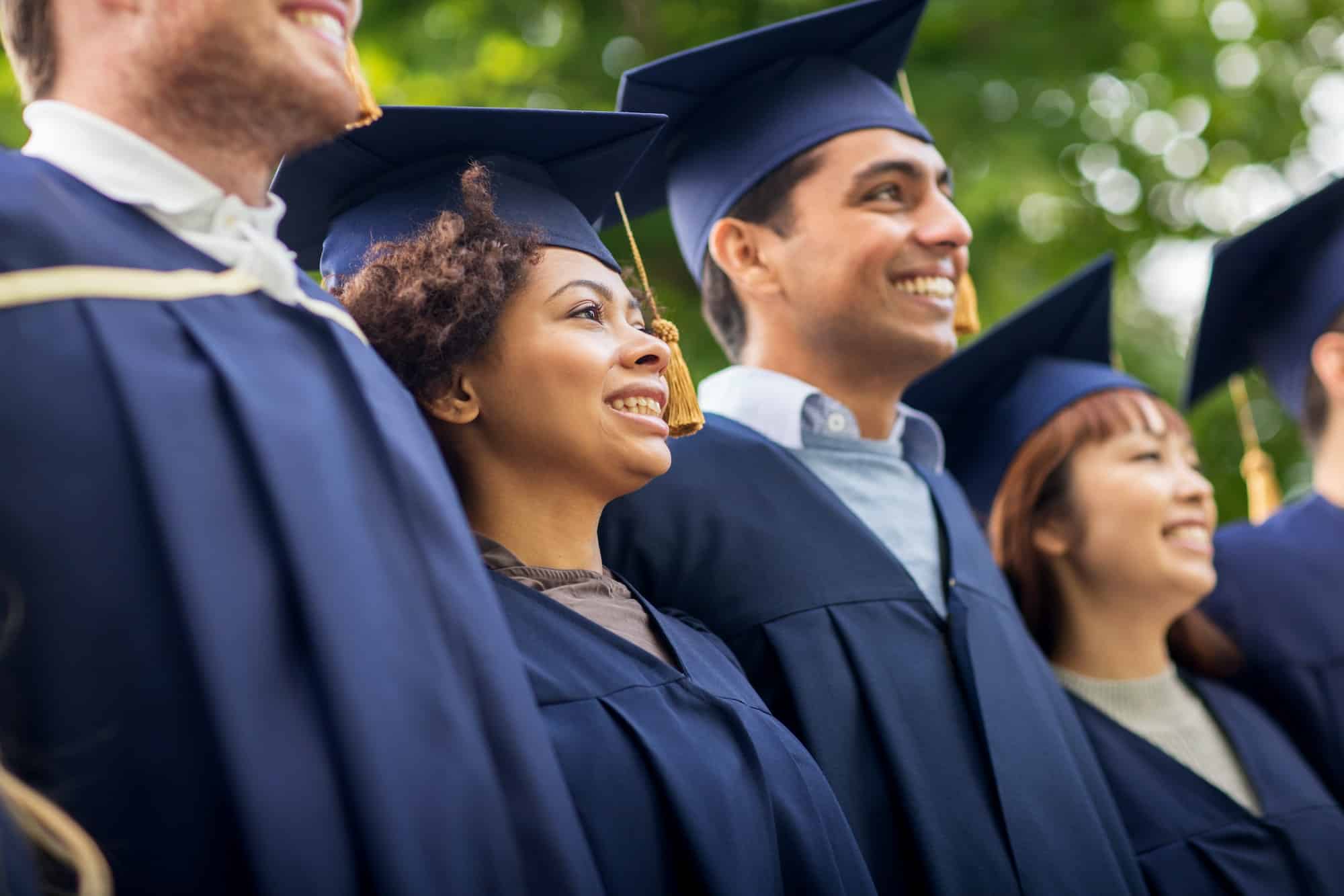 happy students or bachelors in mortar boards