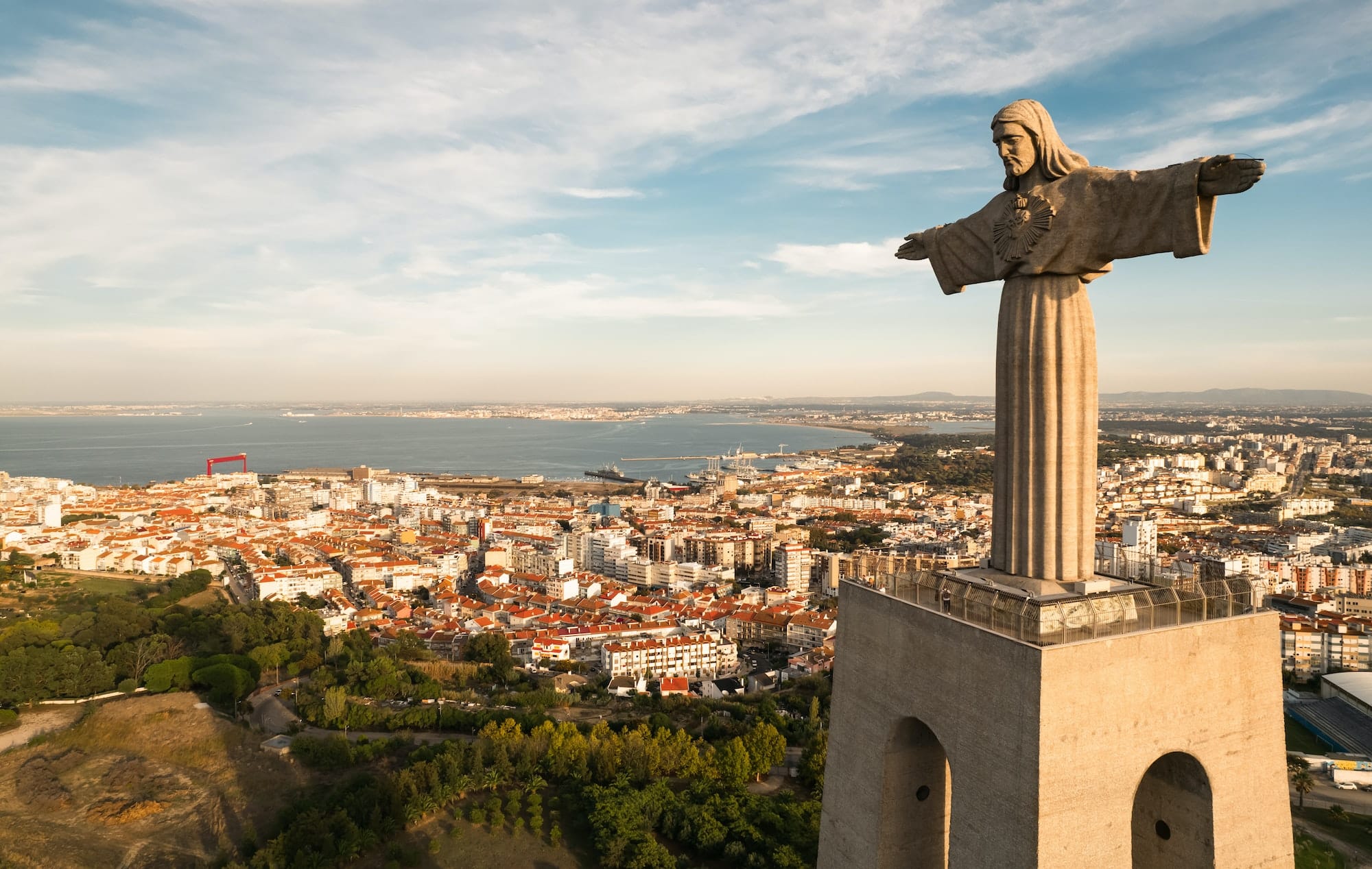 Historic statue of Christ the King over city on sunny day