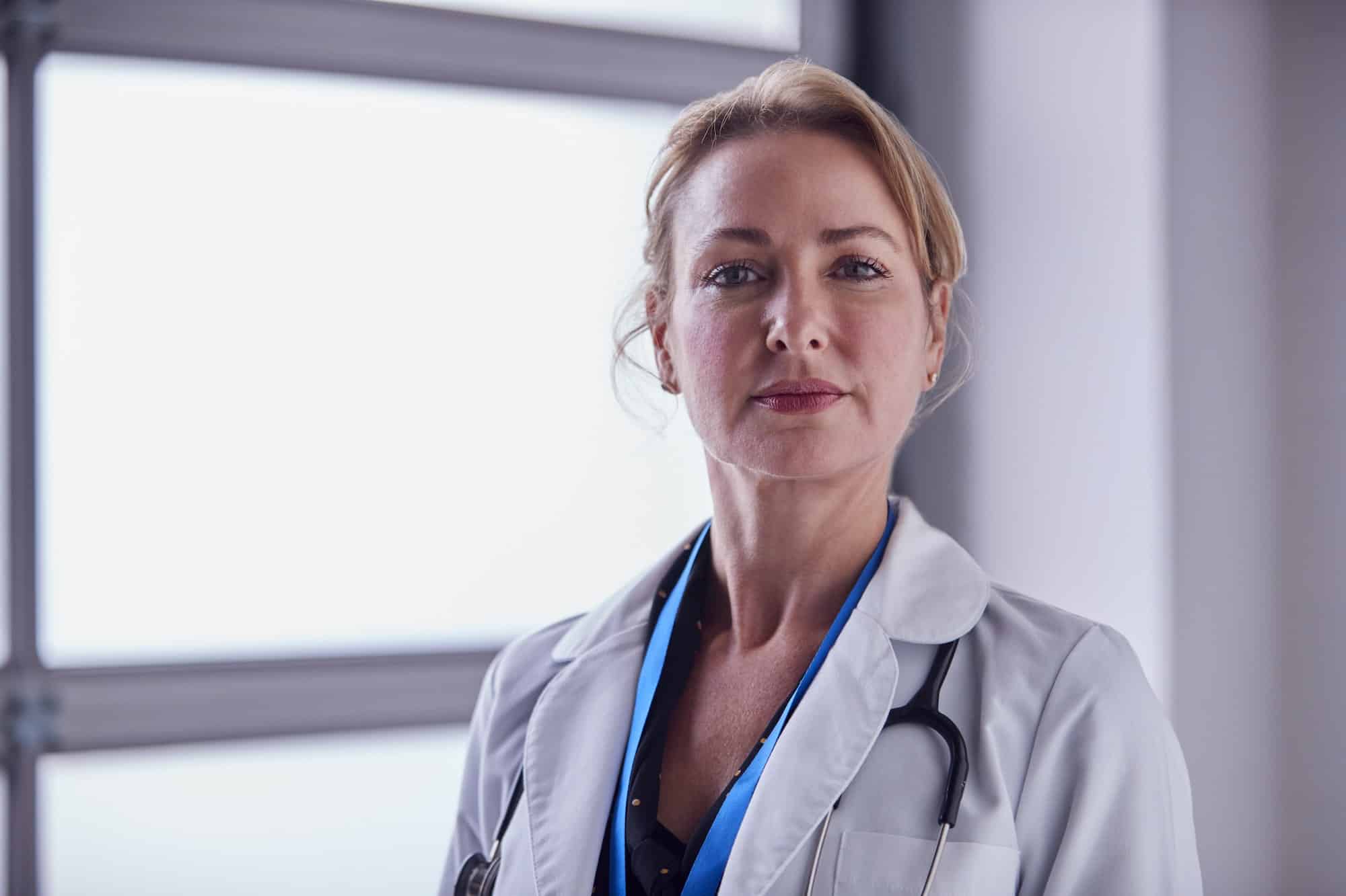 Portrait Of Mature Female Doctor Wearing White Coat In Hospital