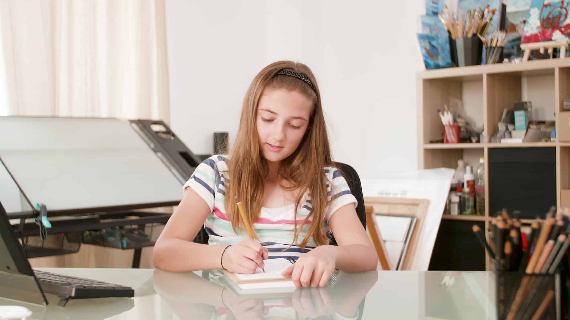 Young schoolgirl writing mathematics exercices on notebook