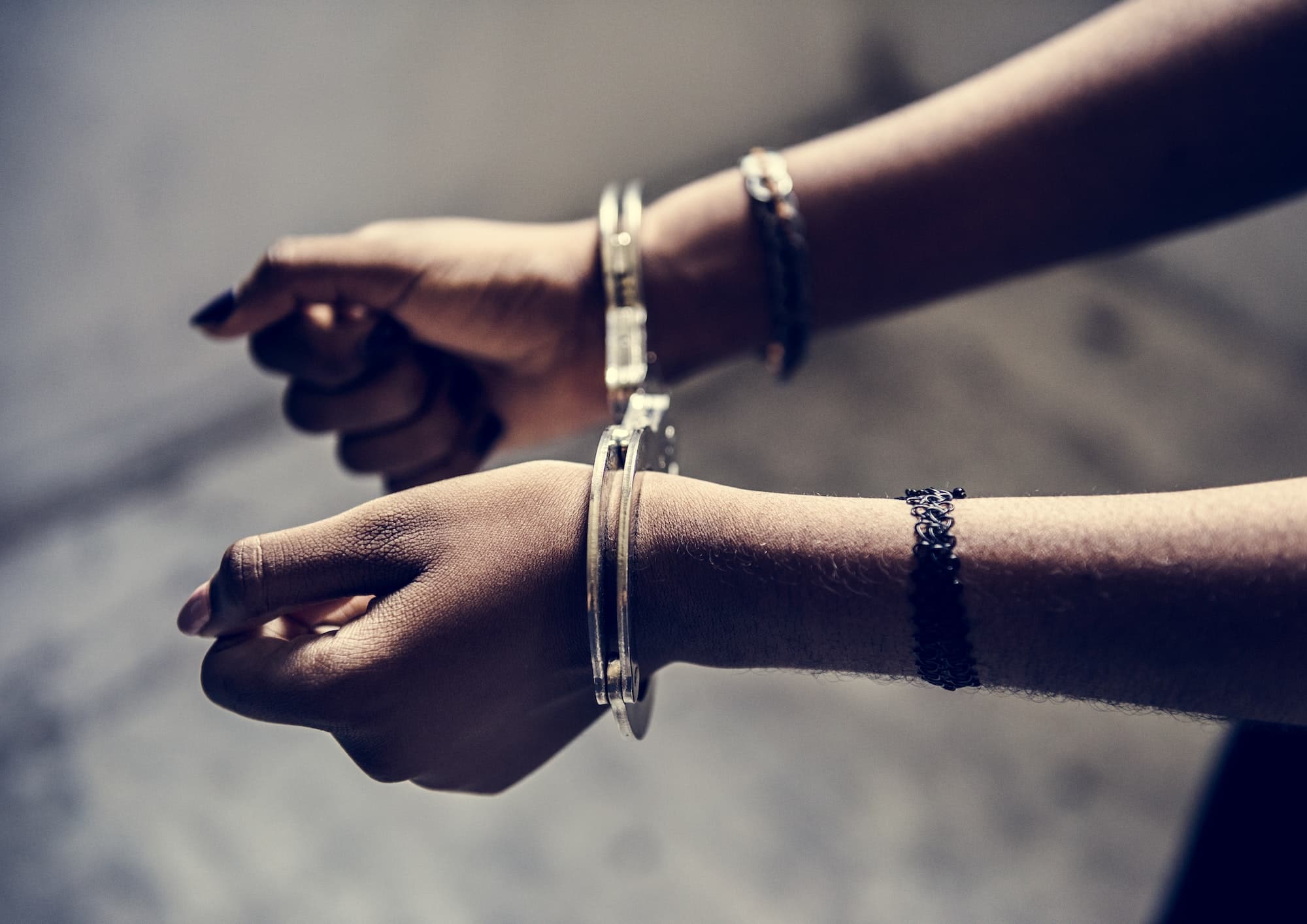 Closeup of arrested hands with handcuffs