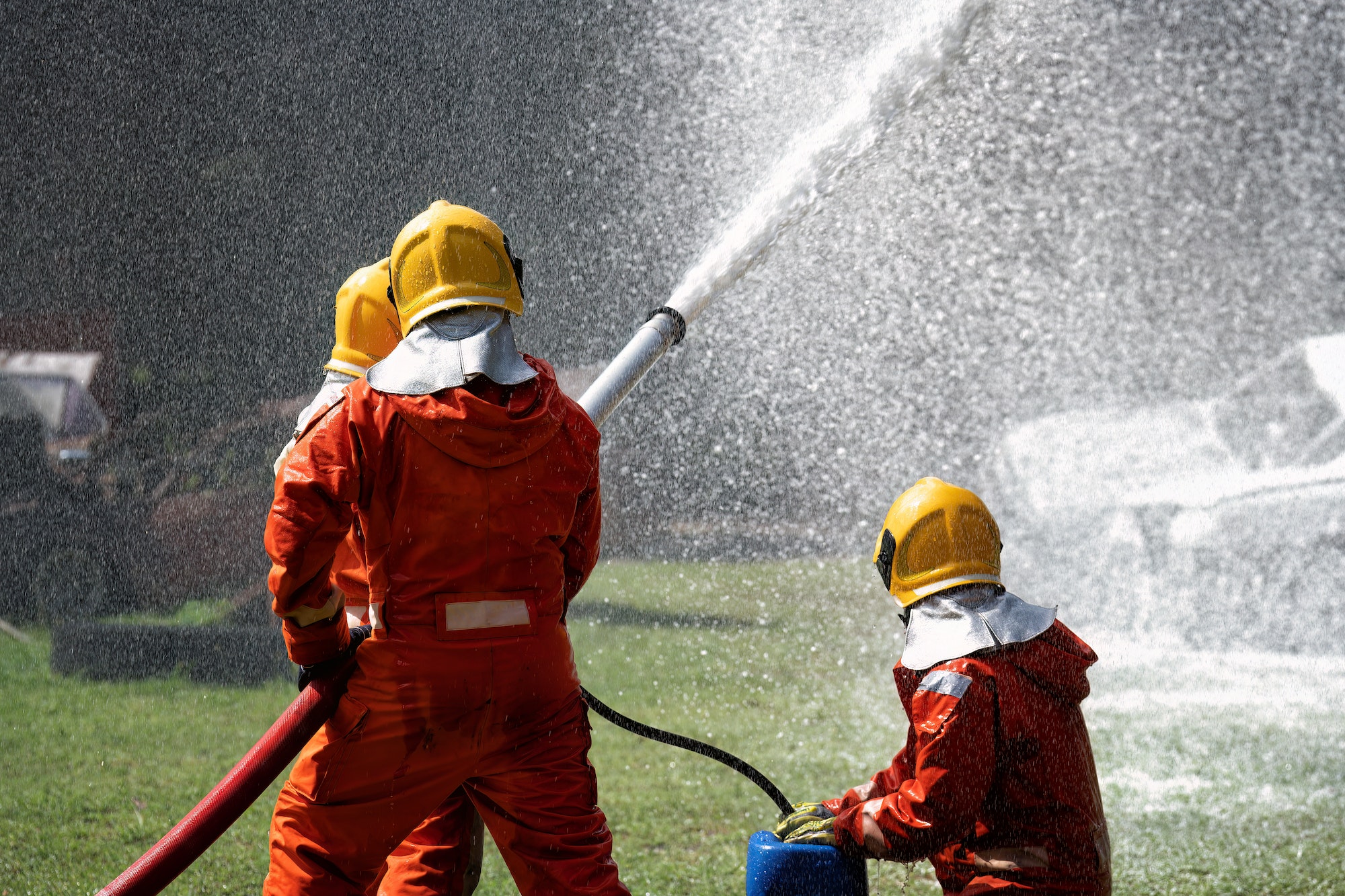 fire fighter team on training fight with gas and oil spray turbulence water to distinguished fire