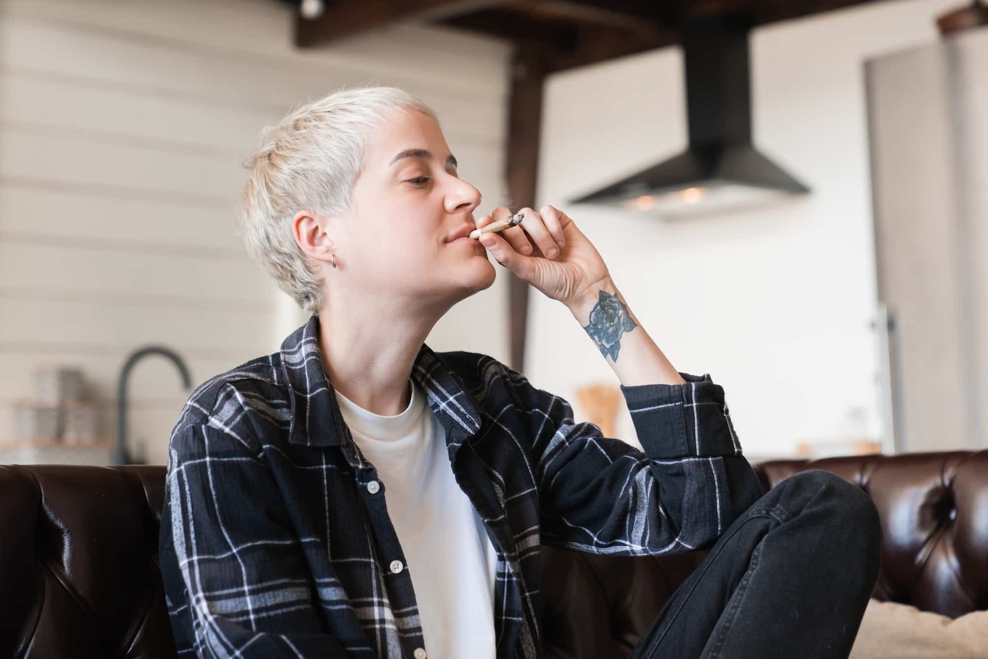 Hipster woman girl smoking cigarette joint with marijuana cannabis tobacco hashish