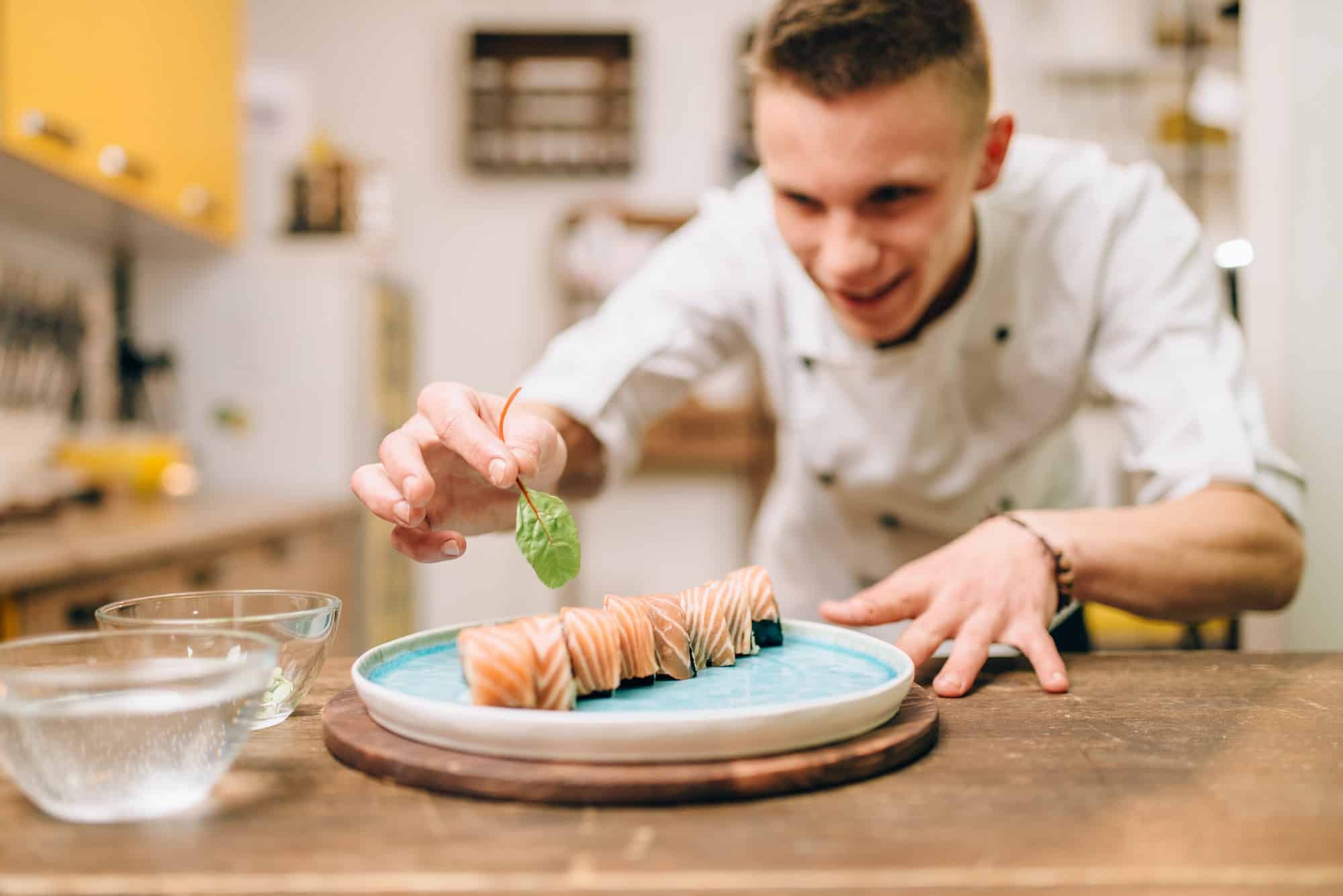 Man cooking sushi rolls, japanese kitchen