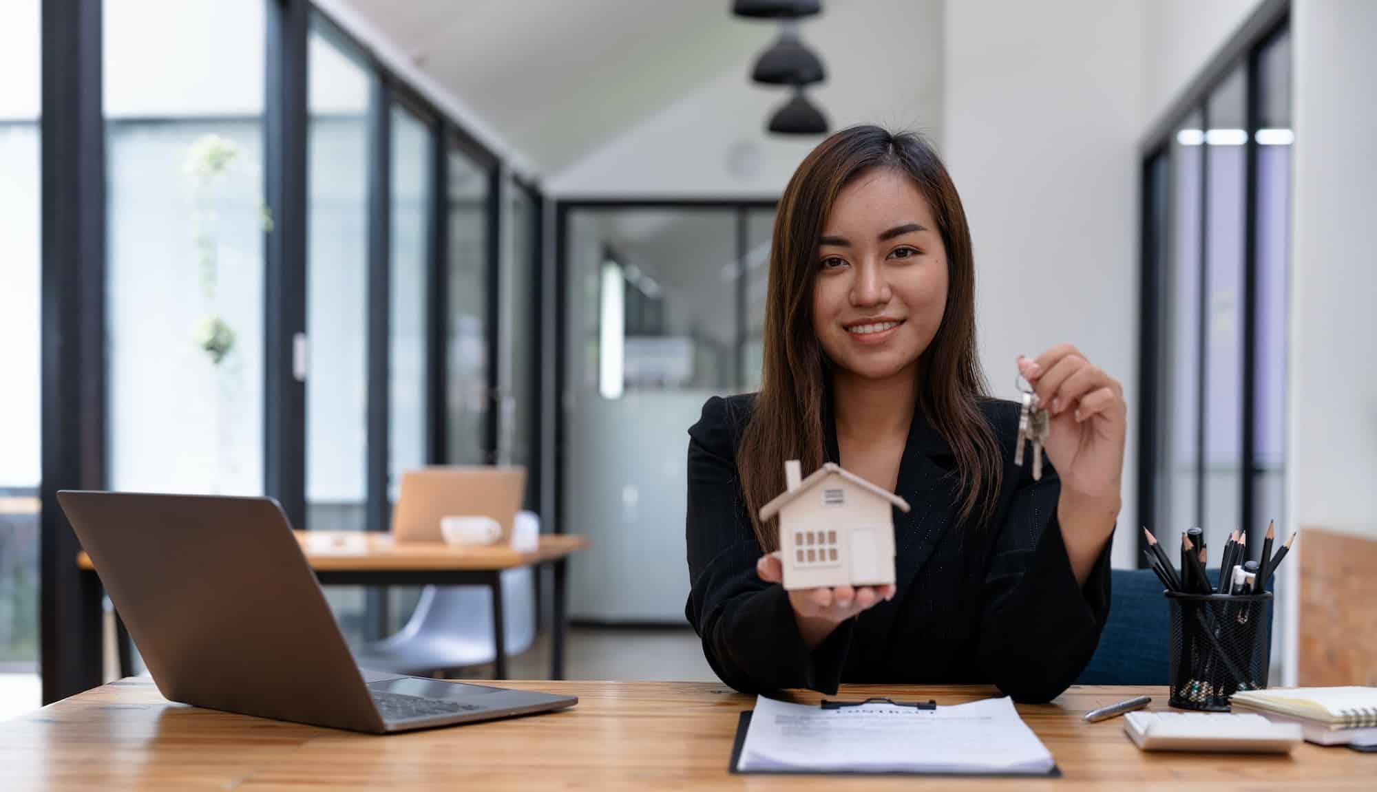 Real estate agent handing over keys house and model, rental and sell insurance concept.