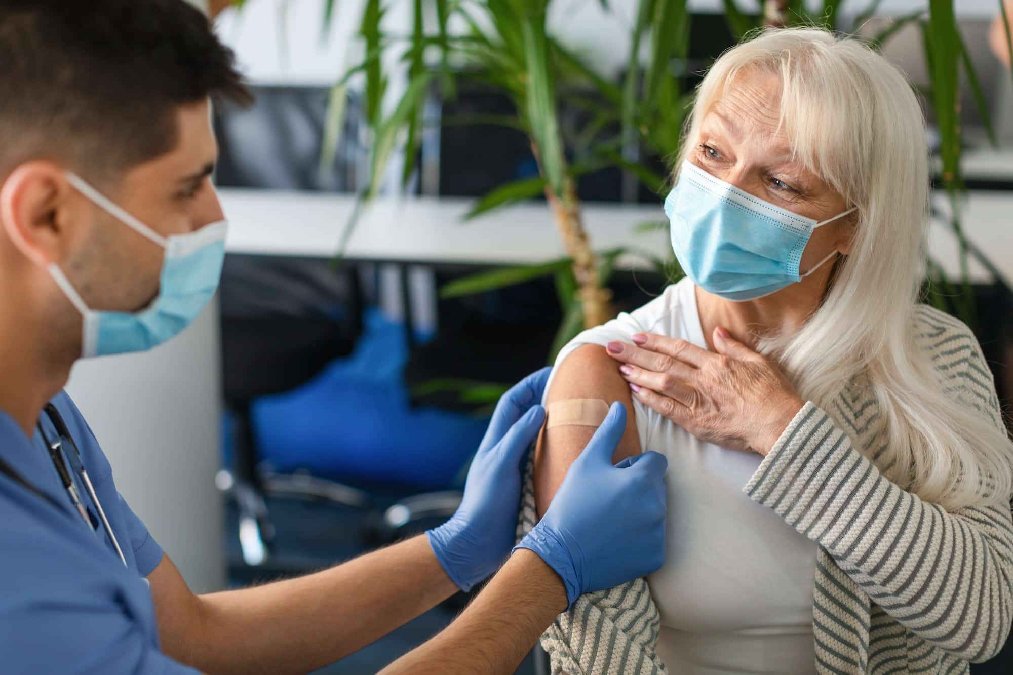 Senior Lady Getting Vaccinated Against Covid, Doctor Applying Adhesive Bandage