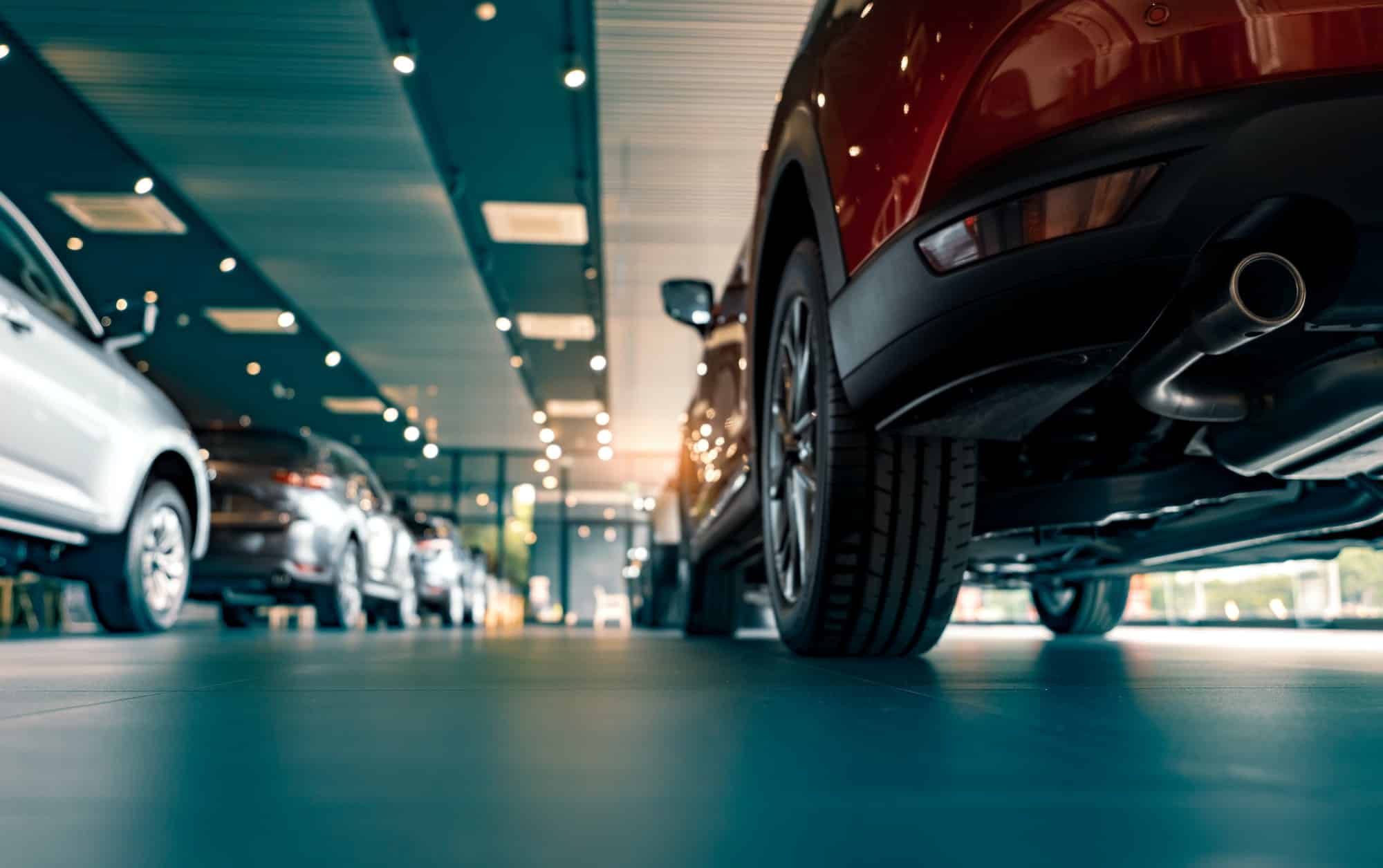 Rearview car parked in luxury showroom. Car dealership office. New car parked in modern showroom.