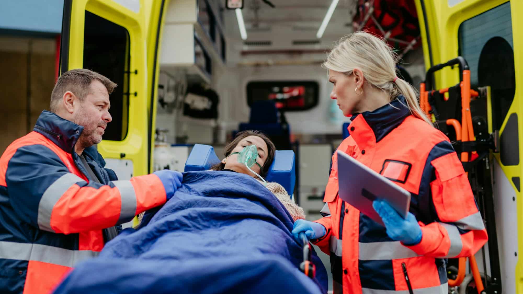 Rescuers taking care of patient, preparing her for transport.