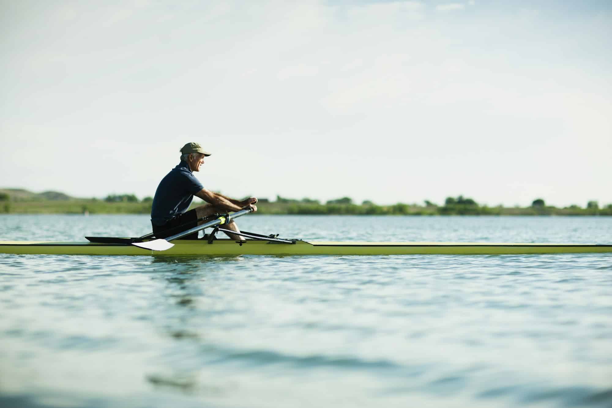 A middle-aged man in a rowing boat on the water.