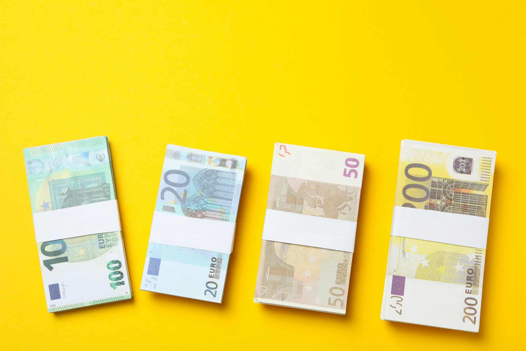 Euro money on yellow background, top view