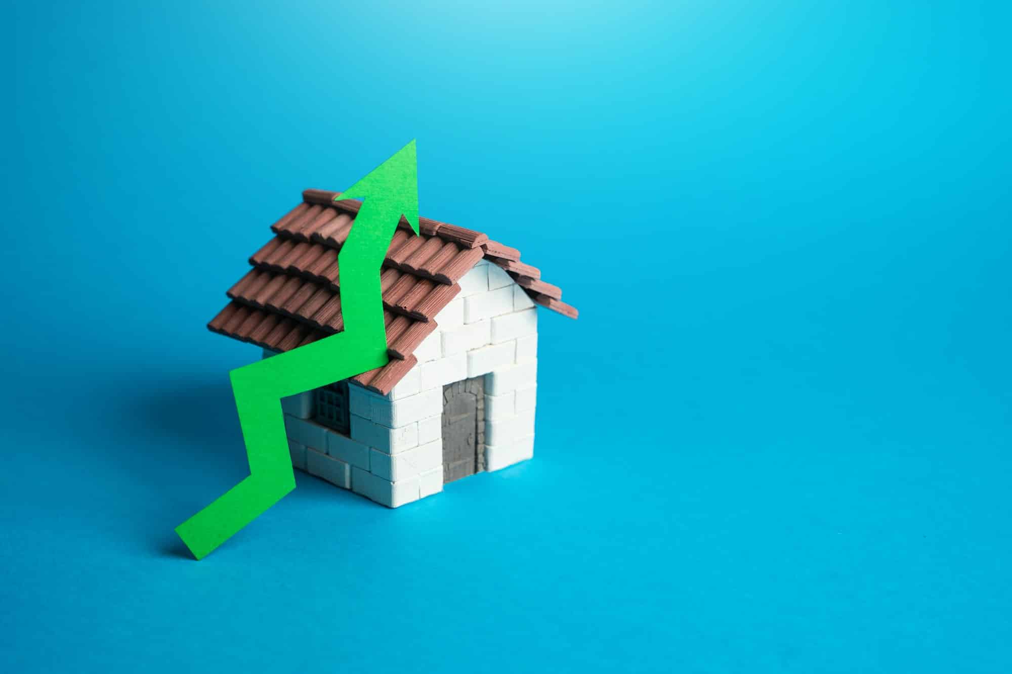 House and green arrow up. Rising housing prices.