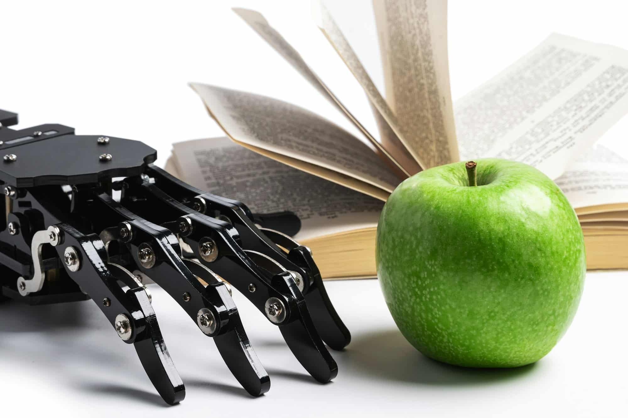 Real robotic hand and opened book. Concept of AI power and machine learning