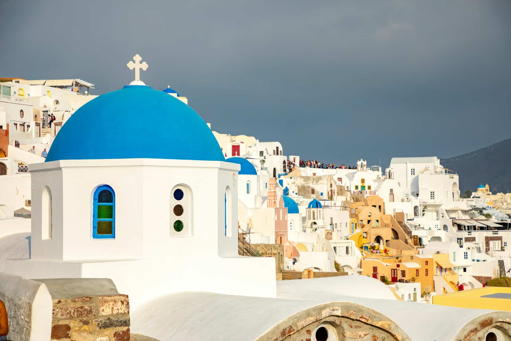 Traditional and famous houses and churches with blue domes in Oia, Santorini in Greece