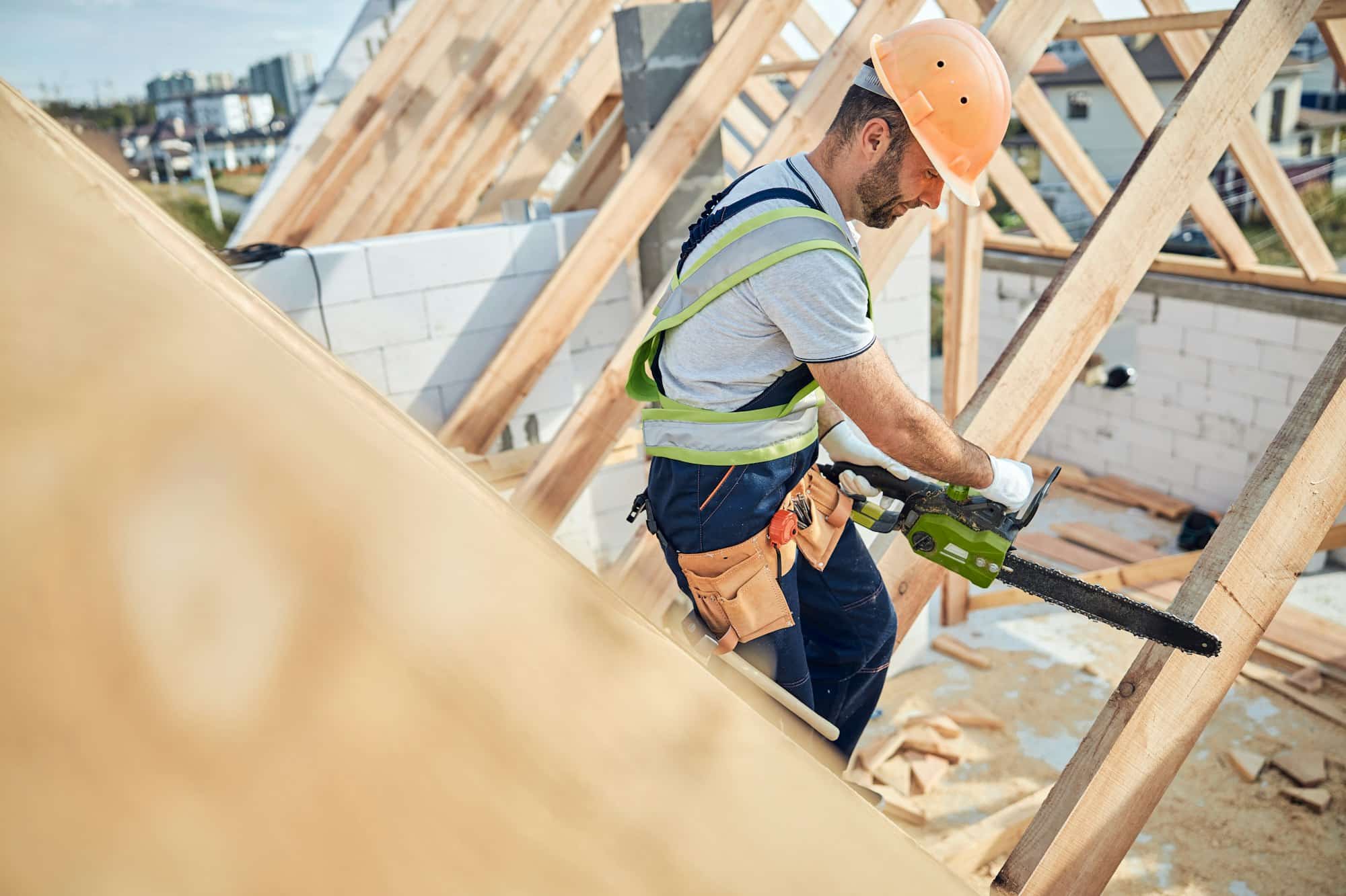 Certified builder using a chainsaw at a constraction site