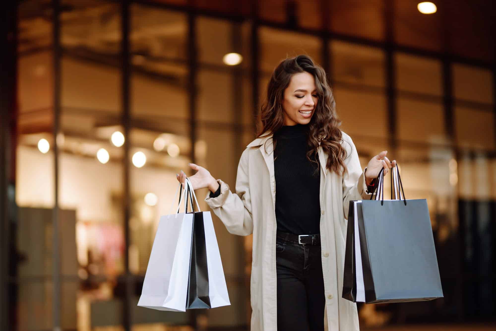 Young woman with shopping bags near mall. Spring Style. Consumerism, purchases, shopping, lifestyle.