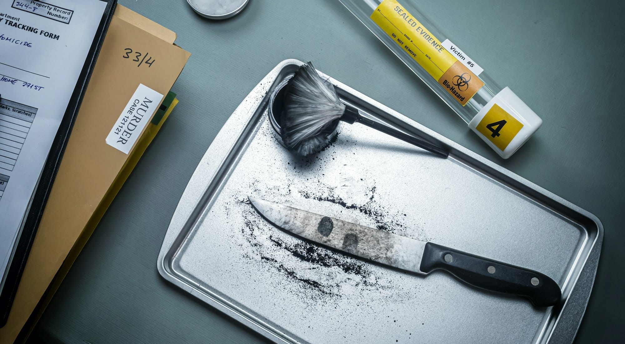 Fingerprint development on a knife involved in a homicide in a crime lab, conceptual image